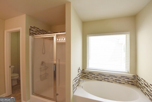 bathroom with a bath, a stall shower, tasteful backsplash, and toilet