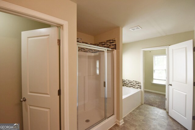 bathroom featuring a shower stall, visible vents, and a garden tub