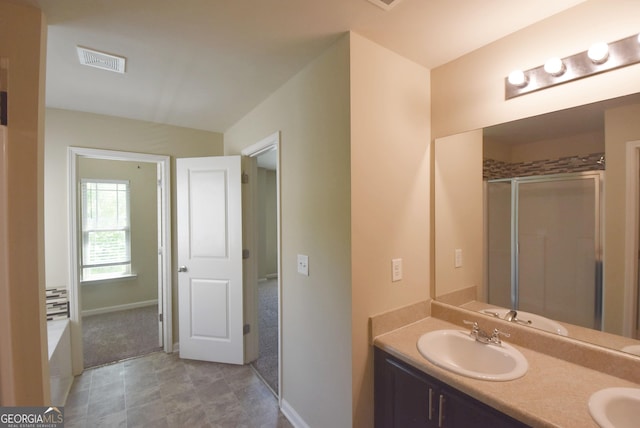 full bathroom with double vanity, visible vents, a stall shower, and a sink