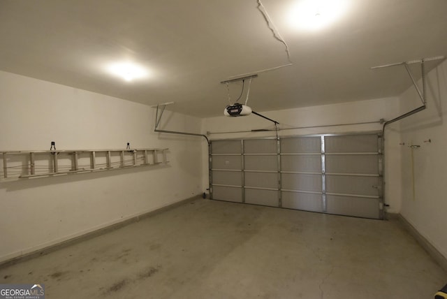 garage featuring a garage door opener and baseboards