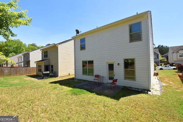 back of property featuring fence, a lawn, and a patio area