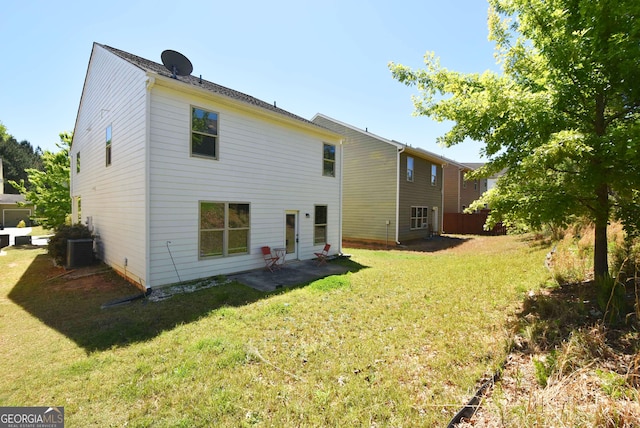 rear view of house featuring central air condition unit and a yard