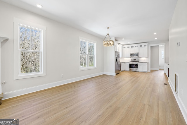 405 Roper Dr, Clarkesville, GA 30523 - unfurnished living room featuring light wood-style flooring, baseboards, recessed lighting, and a notable chandelier
