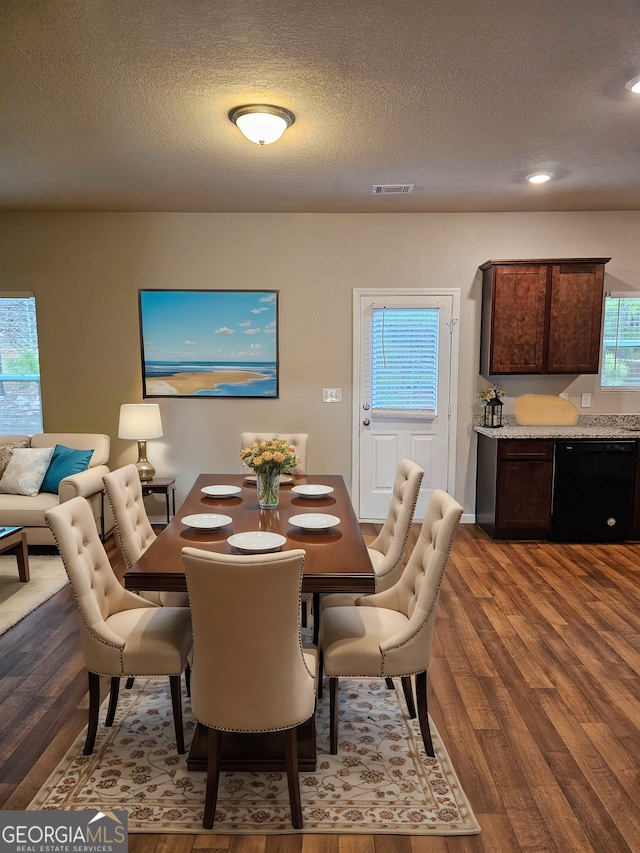 dining room with recessed lighting, wood finished floors, visible vents, and a textured ceiling