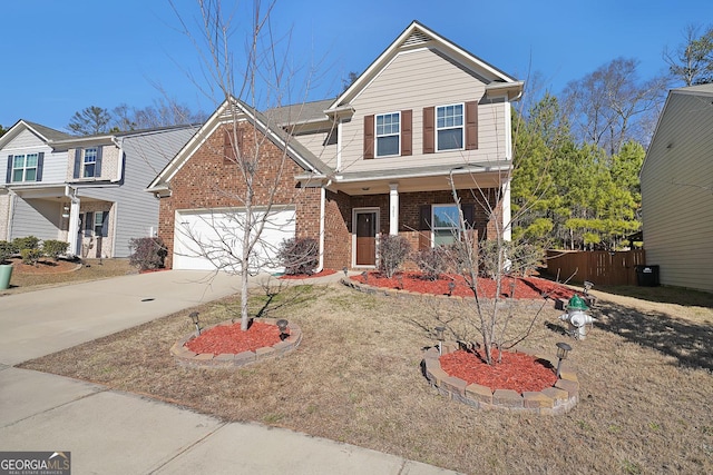 traditional home featuring fence, concrete driveway, an attached garage, covered porch, and brick siding