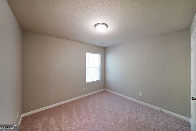 carpeted spare room with baseboards and a textured ceiling