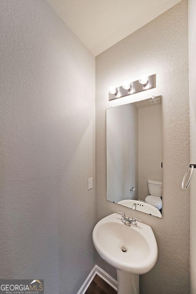 bathroom with a textured wall and a sink