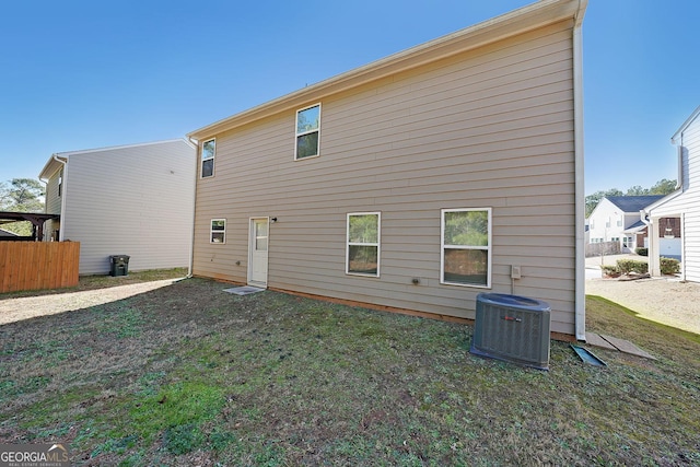 rear view of property featuring cooling unit and a yard