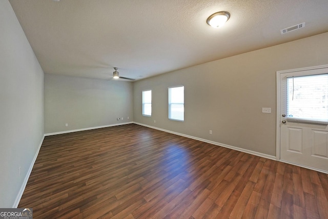 interior space featuring ceiling fan, baseboards, dark wood-style flooring, and visible vents