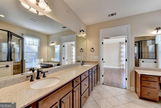 full bath featuring visible vents, a sink, a shower stall, and double vanity