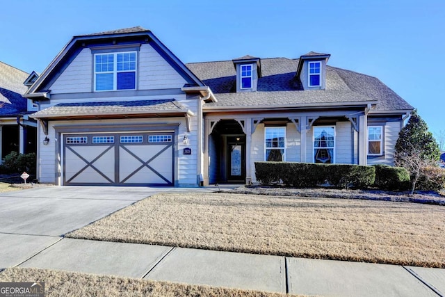 view of front facade featuring an attached garage, driveway, and roof with shingles
