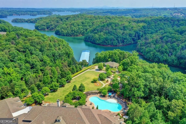drone / aerial view featuring a forest view and a water view