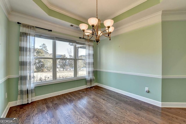 unfurnished room with a tray ceiling, wood finished floors, crown molding, baseboards, and a chandelier