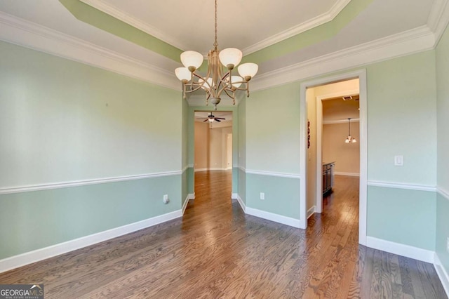unfurnished dining area with ceiling fan with notable chandelier, baseboards, wood finished floors, and ornamental molding