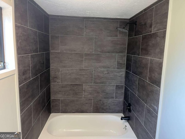bathroom with a textured ceiling and  shower combination
