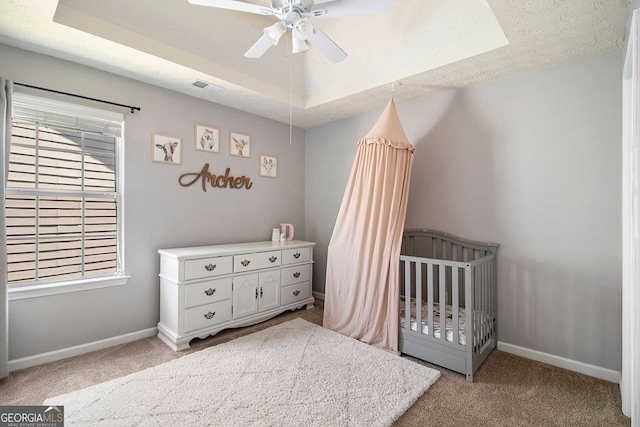5 Stony Oak Dr, Newnan, GA 30263 - carpeted bedroom with baseboards, a tray ceiling, a crib, and a ceiling fan