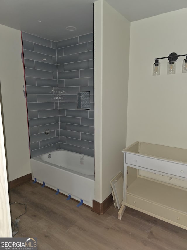 full bath with wood finished floors, tub / shower combination, and baseboards