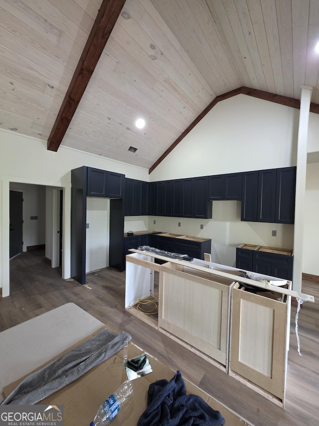 kitchen with wooden ceiling, a kitchen island, wood finished floors, and high vaulted ceiling
