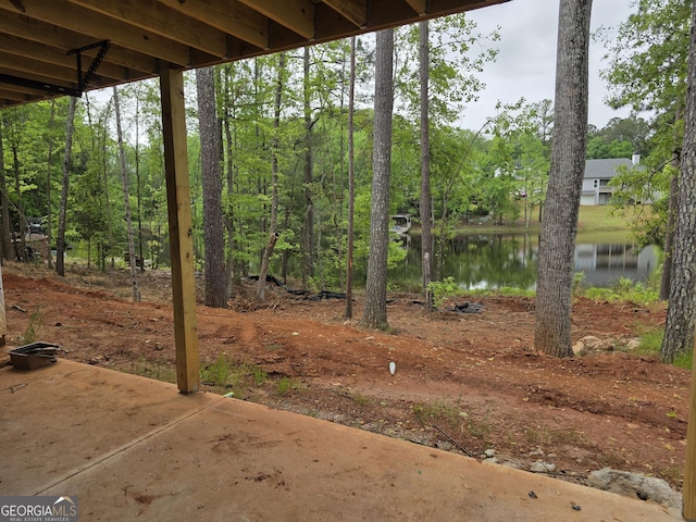 view of yard with a water view and a patio