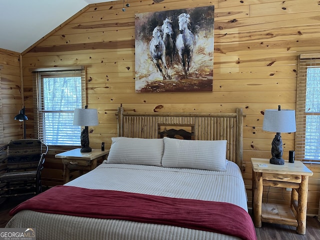 bedroom featuring wood finished floors, wooden walls, multiple windows, and lofted ceiling
