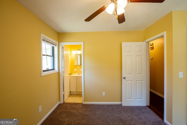 unfurnished bedroom featuring carpet flooring, a sink, baseboards, ceiling fan, and connected bathroom