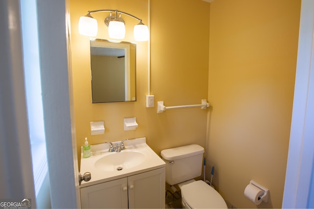 half bathroom with vanity and toilet