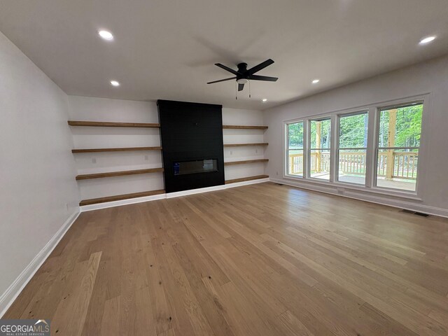 409 Saint Surrey Way, Ellenwood, GA 30294 - unfurnished living room featuring visible vents, baseboards, light wood finished floors, a fireplace, and a ceiling fan