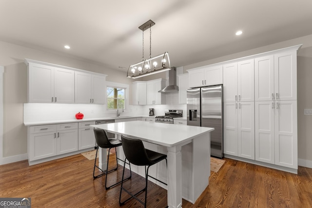 527 Abby, Clayton, GA 30525 - kitchen featuring appliances with stainless steel finishes, wall chimney range hood, a kitchen bar, a kitchen island, and white cabinets