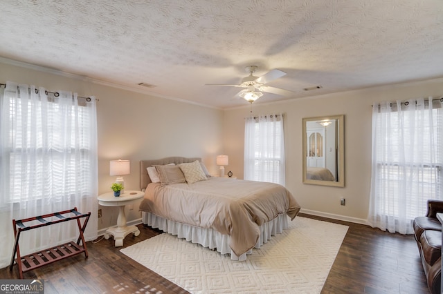 bedroom featuring a textured ceiling, crown molding, and dark wood-style flooring