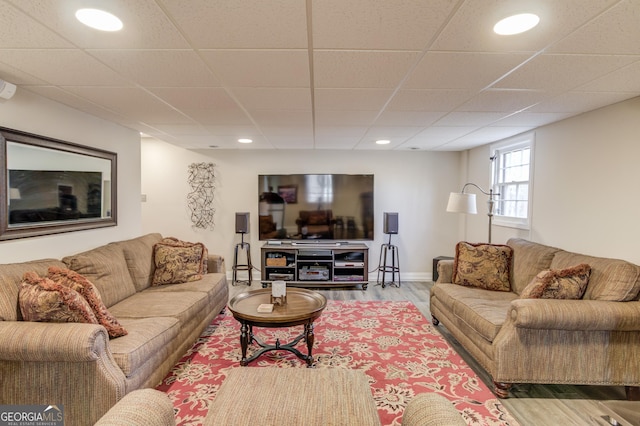 living area featuring recessed lighting, a paneled ceiling, baseboards, and wood finished floors