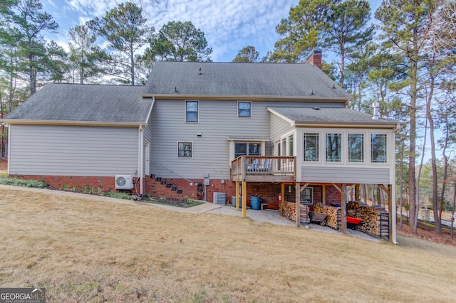 back of property featuring a shingled roof, a chimney, and a deck