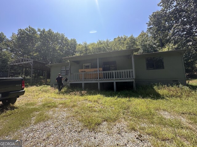 view of front of home with a porch and a carport