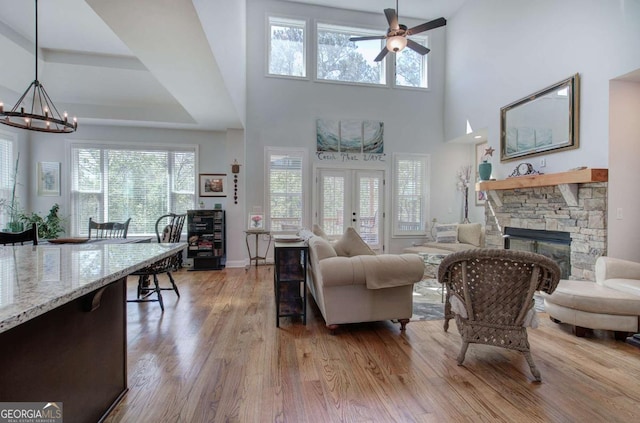 17 Ivy Stone Ct SE, Cartersville, GA 30120 - living room with a stone fireplace, a wealth of natural light, wood finished floors, and ceiling fan with notable chandelier