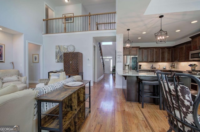 17 Ivy Stone Ct SE, Cartersville, GA 30120 - kitchen featuring a kitchen breakfast bar, light stone counters, dark brown cabinets, light wood-type flooring, and appliances with stainless steel finishes
