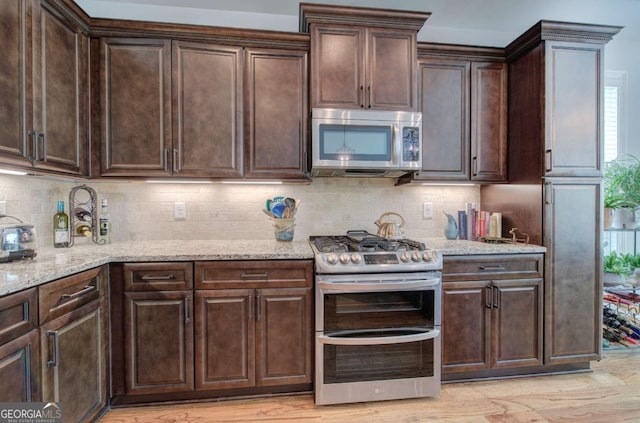 17 Ivy Stone Ct SE, Cartersville, GA 30120 - kitchen with light stone counters, dark brown cabinetry, light wood-style flooring, tasteful backsplash, and appliances with stainless steel finishes