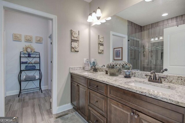 17 Ivy Stone Ct SE, Cartersville, GA 30120 - bathroom featuring a tile shower, double vanity, baseboards, and a sink