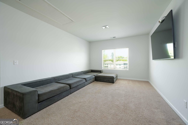 unfurnished living room featuring attic access, baseboards, and carpet flooring