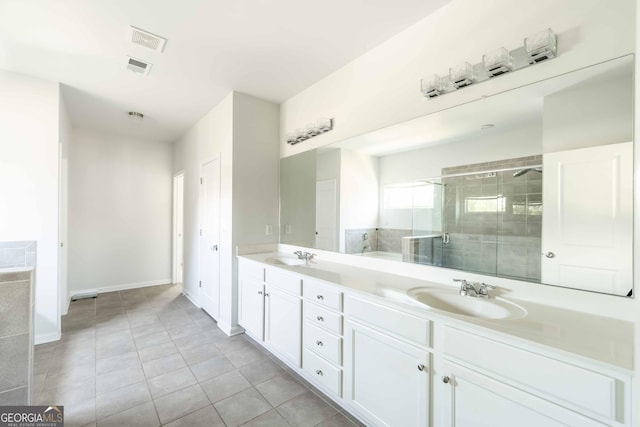 full bath with a shower stall, tile patterned flooring, double vanity, visible vents, and a sink