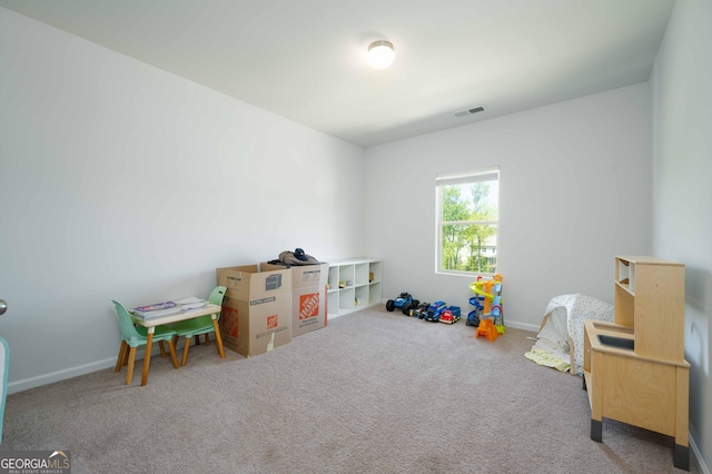 rec room with carpet, visible vents, and baseboards