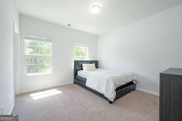 carpeted bedroom featuring baseboards and visible vents
