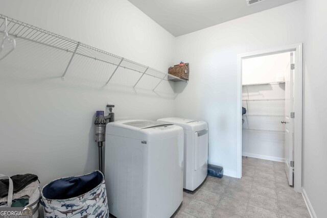 laundry area featuring washing machine and clothes dryer, baseboards, and laundry area