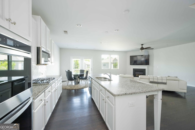 kitchen with a sink, visible vents, a ceiling fan, dark wood-type flooring, and appliances with stainless steel finishes