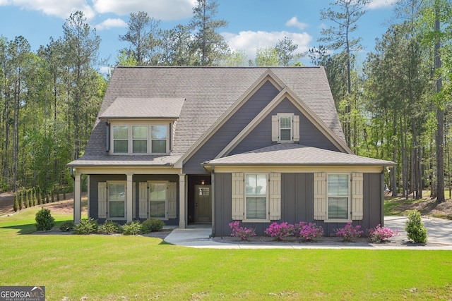 craftsman-style house with a front lawn, roof with shingles, and board and batten siding