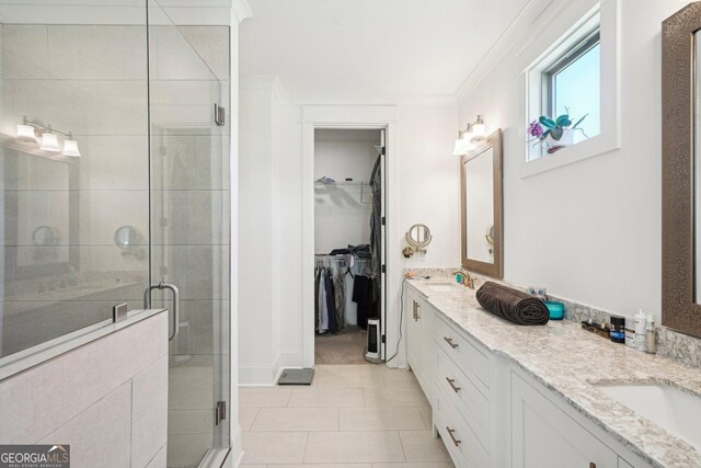 full bathroom with tile patterned flooring, a sink, a shower stall, and double vanity