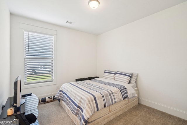 carpeted bedroom with visible vents and baseboards