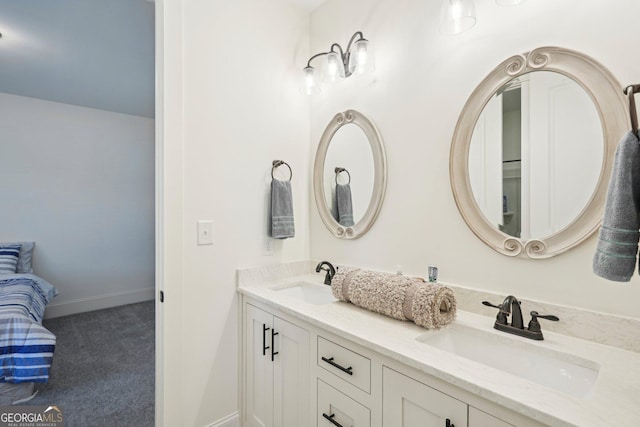 full bath featuring double vanity, baseboards, and a sink