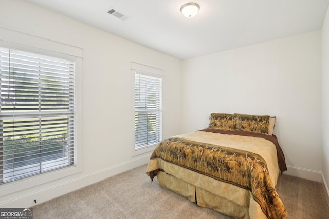 carpeted bedroom featuring baseboards and visible vents