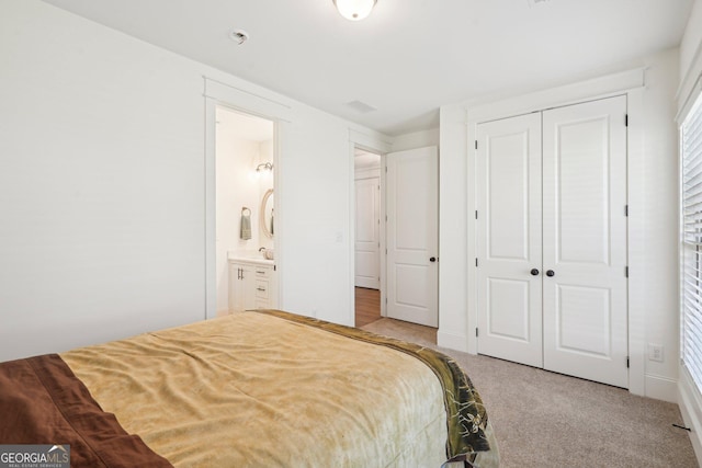 carpeted bedroom featuring visible vents, connected bathroom, and a closet