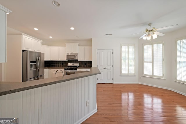 15 Boxelder Ct, Dallas, GA 30132 - kitchen featuring dark countertops, light wood-style floors, stainless steel appliances, backsplash, and visible vents