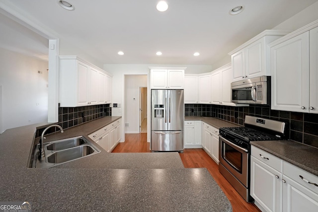 15 Boxelder Ct, Dallas, GA 30132 - kitchen featuring dark countertops, a sink, decorative backsplash, white cabinets, and appliances with stainless steel finishes